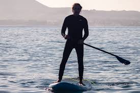 A person paddleboarding on calm waters off the coast of Myrtle Beach.